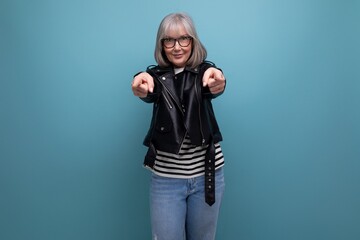successful healthy gray-haired woman 50s grandmother businesswoman in a rocker jacket on a bright background with copy space