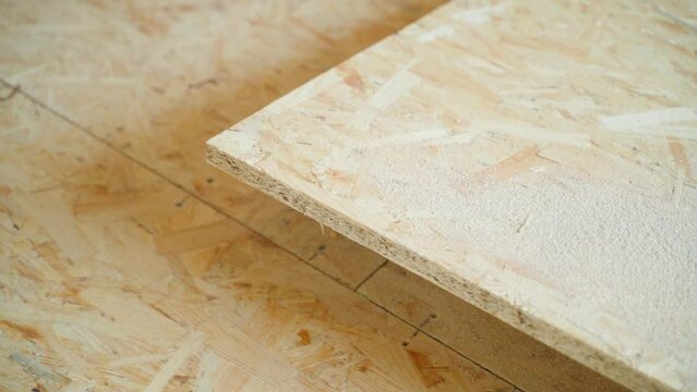 Cropped osb sheet close-up. Oriented strand board on the floor, custom sized. small wood shavings