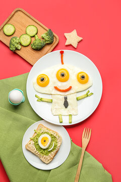 Naklejki Plates with funny children's breakfast in shape of alien and vegetables on red background