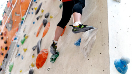 the girl on the climbing wall does sports - obrazy, fototapety, plakaty