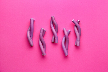 Hair curlers on pink background