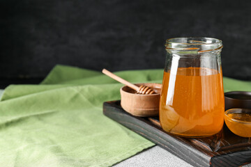 Jar of sweet honey on table