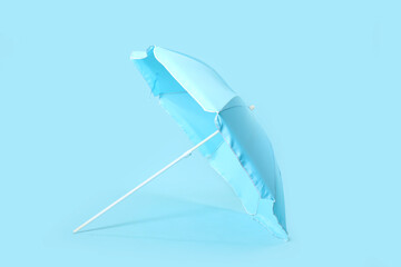 Fototapeta na wymiar Beach umbrella on blue background