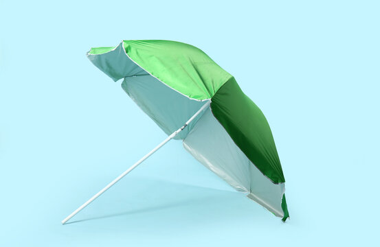 Green beach umbrella on blue background