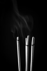 Incense sticks and incense stick smoke on black backgrond with white backlit