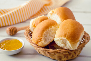 Soft bread rolls in wicker basket and jam