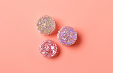 Jars of glitter on pink background