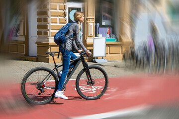 Junge Fahrradfahrerin in der Stadt auf einem rot markierten Radweg (Model released)