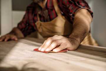 Carpenter works with wood in the workshop. Small business, production, craft concept.