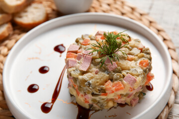 Plate of tasty Olivier salad on table, closeup