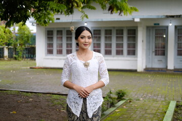 A young Indonesian woman with a happy successful expression wearing a white kebaya. Kartini's Day...