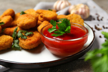 Plate of tasty nuggets with ketchup on table, closeup