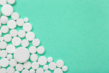 White pills on mint background