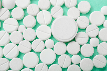 White pills on mint background