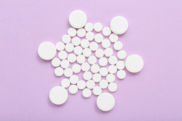 White pills on lilac background