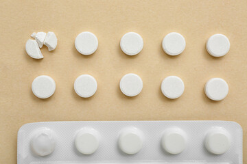 Blister with white pills on beige background