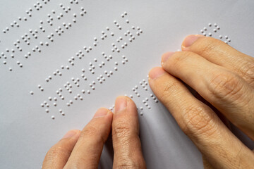 Blind person reading braille of alphabet A to Z