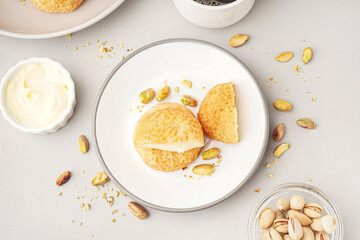 Plate with tasty choux dessert on light background