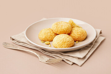 Plate with tasty choux dessert on beige background