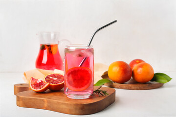 Glass of tasty blood orange lemonade on light background