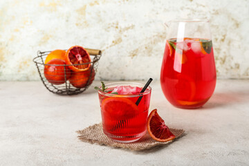 Glass of tasty blood orange lemonade on light background