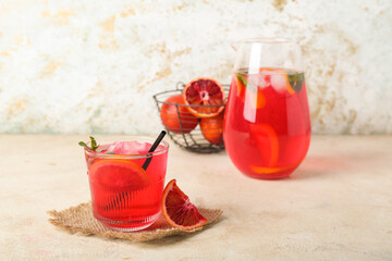 Glass of tasty blood orange lemonade on light background