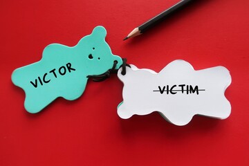 Bear notebook with pencil writing VICTIM and VICTOR, to overcome victim mentality (feels like have...