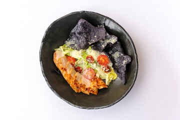 Caesar salad with chicken on a black plate