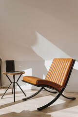 Minimalist home office workspace interior design concept. Leather armchair, laptop computer on side...