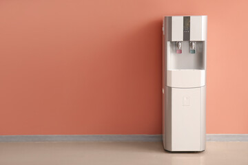 Modern water cooler near coral wall