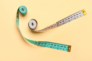 White and blue measuring tapes on beige background