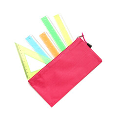 Colorful rulers and pencil case on white background