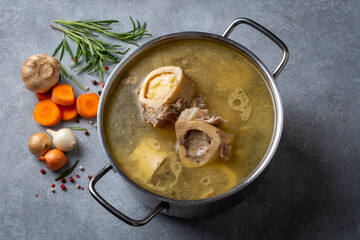 Boiled bone and broth. Homemade beef bone broth is cooked in a pot on. Bones contain collagen,...