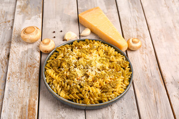 Plate of tasty Italian pasta with Parmesan cheese on light wooden background