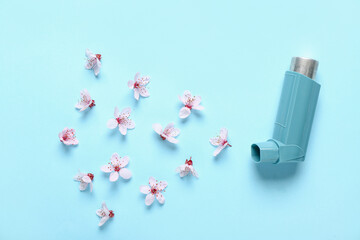 Inhaler with flowers on blue background