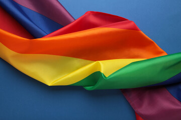 The rainbow flag (LGBT) on blue background. Top view.