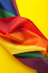 The rainbow flag (LGBT) on yellow background. Vertical photo.