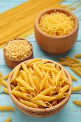 Various types of Italian pasta on blue background
