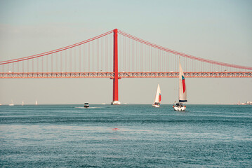 Sailing boats and thhe Ponte 25 de Abril or 25the April Bridge at the Rio Tejo near the City of...