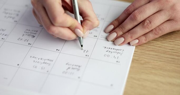 Business planning and businesswoman working and checking calendar at workplace. Taking notes in planner managing time