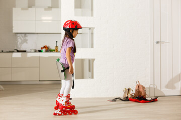 little girl is roller skating at home