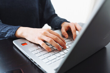 female hands on laptop keyboard