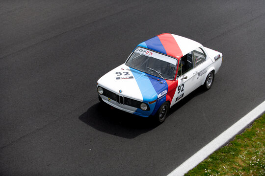 Vintage racing car, classic retro motor sport action, BMW 2002 TI on asphalt race track