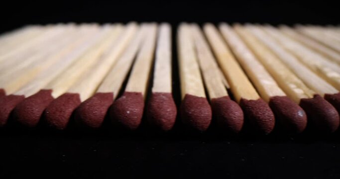 Wooden matches with brown black head on black background. Careless handling of fire and risk to life