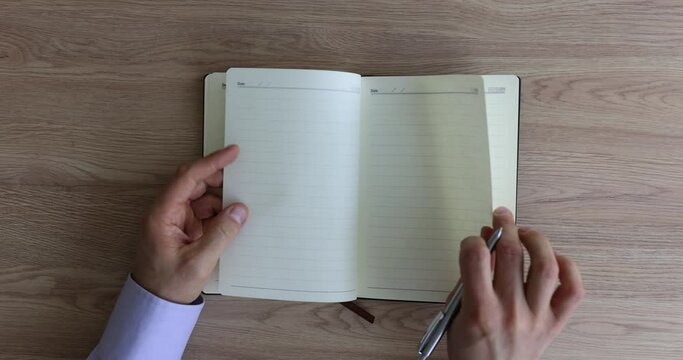 Man hand flips through blank pages of notebook. Creative crisis study of inner emptiness