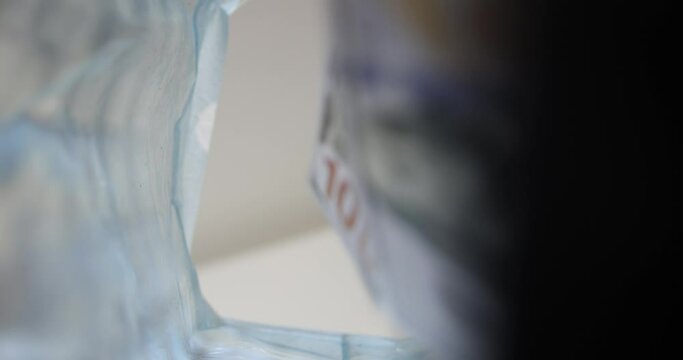 Closeup hand throws money one hundred dollar bills into trash can. Irresponsible attitude towards money
