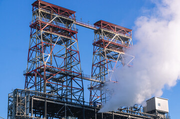 Coke production equipment. Technological equipment for the production of fuel components. White smoke escapes into the atmosphere from the production equipment at the refinery. White smoke 