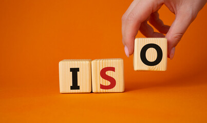 ISO standards quality control symbol. Concept word ISO on wooden cubes. Businessman hand. Beautiful...