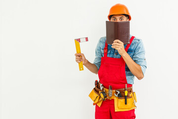 Portrait of cheerful young worker wearing hardhat over white background