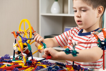 A little boy plays with a constructor, creating figures from gears and sticks. Development of logic...